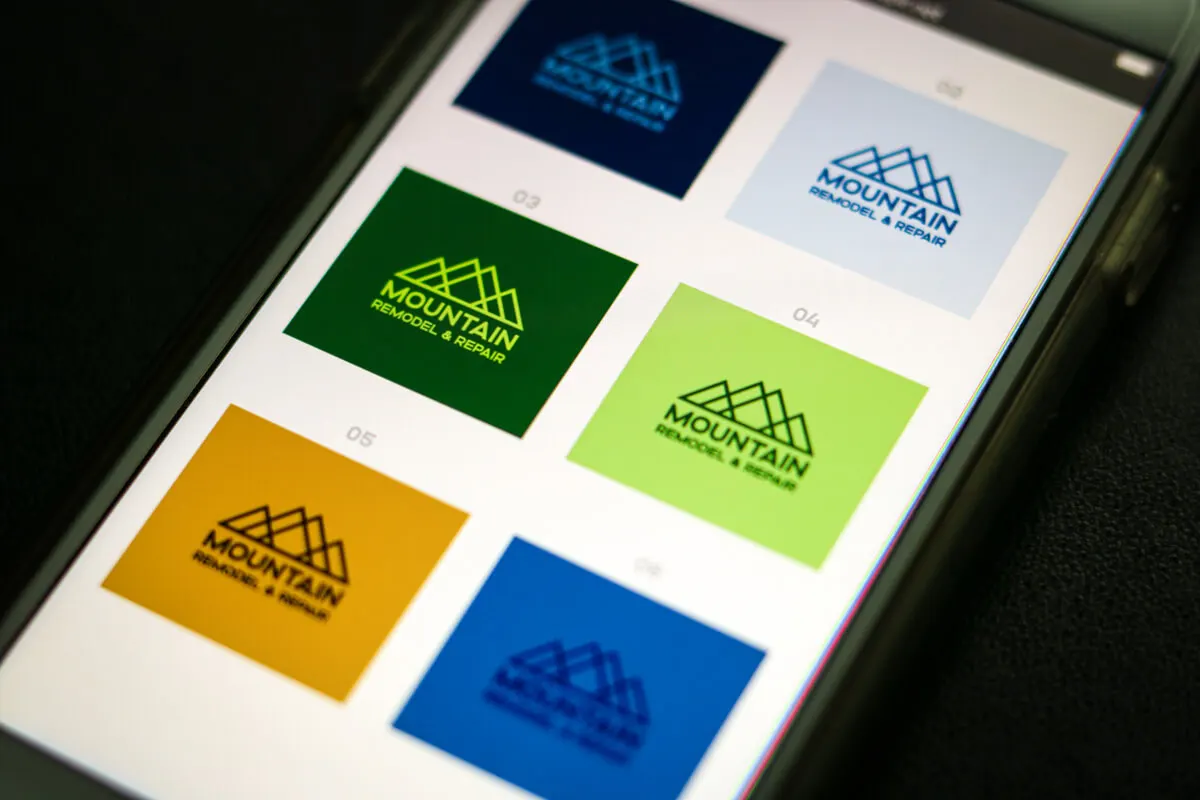 Photo of a phone showing various concepts of a logo for a construction company called Mountain Remodel & Repair